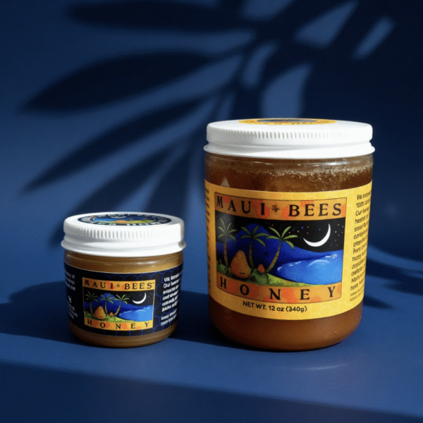 Two jars of Maui Wildflower Winter Honey sit on a blue surface with palm tree shadows. The jars, brimming with rich Maui honey, feature colorful labels depicting a tropical scene with palm trees, ocean, and a crescent moon.