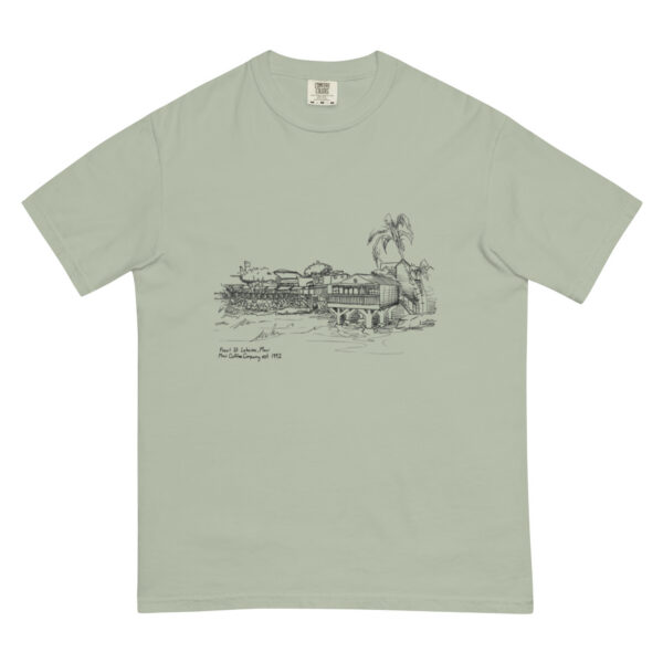 The Front Street Uni-Sex T-Shirt is light green and showcases a black line drawing of a tropical riverside scene with trees, a building, and a small boat; handwritten text is displayed beneath the illustration.