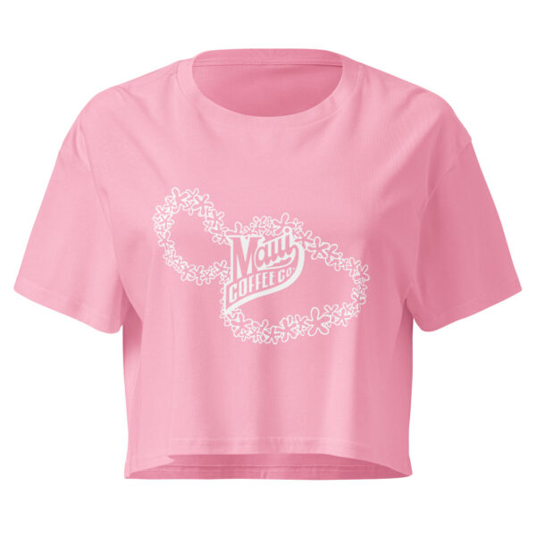 The Women’s White Lei Crop Top is a pink cropped t-shirt with a white graphic that says “Maui Coffee Co” surrounded by a floral lei design.